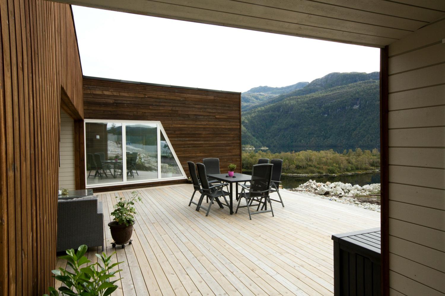 Terrasse med utsikt mot fjell og fjord