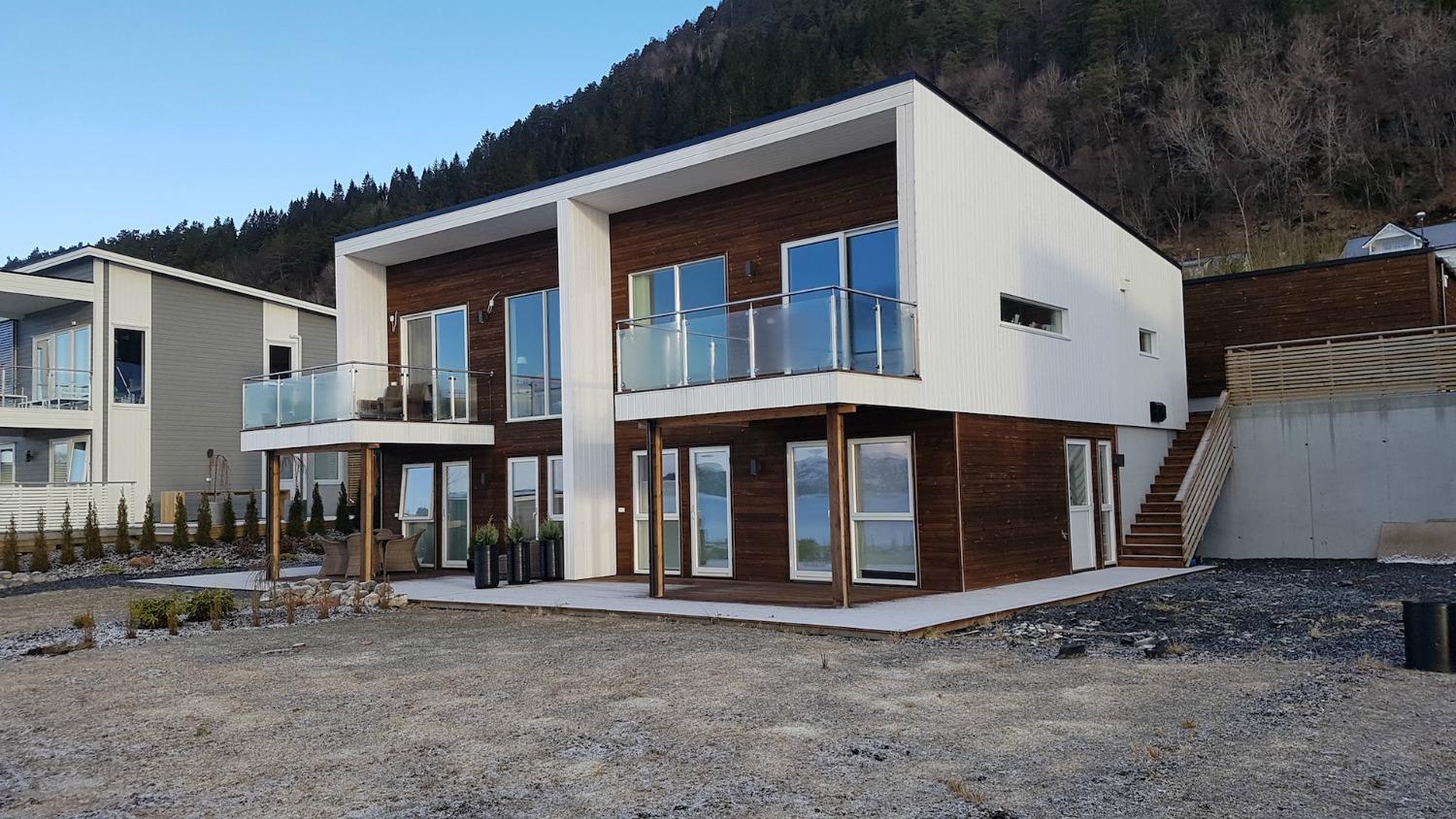 Tomannsbustad i kvitt og brunt med verandaer